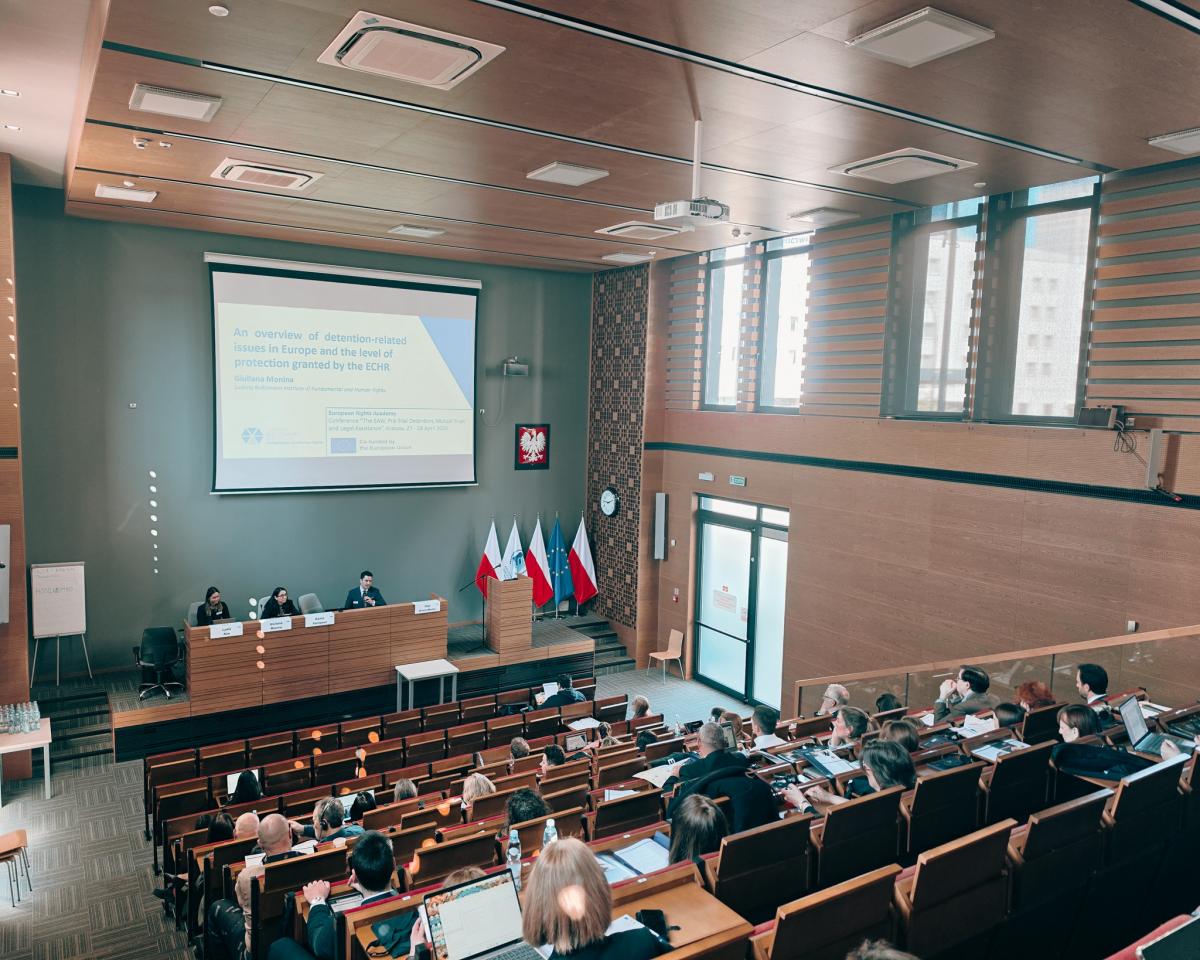 Ramin Farinpour z Akademii Prawa Europejskiego wita z katedry uczestników seminarium. Przy stole prezydialnym od lewej wykładowcy: Lydia Kim, Giuliana Monina