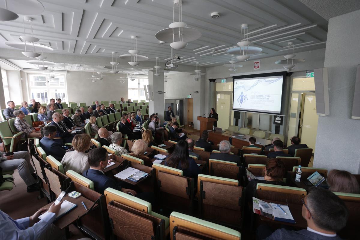 widok sali konferencyjnej KSSIP. Na rzutniku wyświetlany jest temat konferencji.  