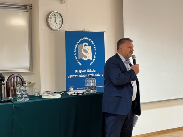 Minister Sprawiedliwości sędzia Waldemar Żurek z mikrofonem trzymanym w dłoni, przemawiający do uczestników
