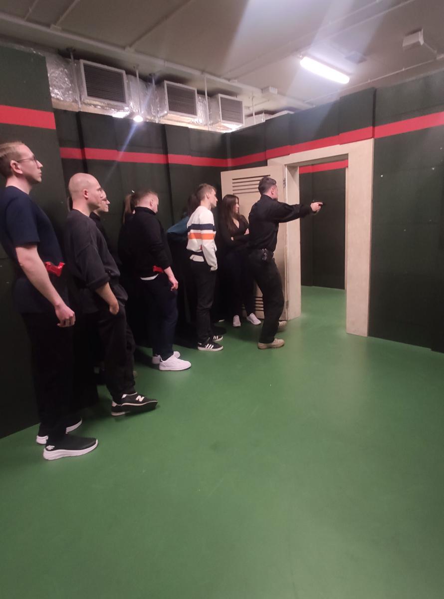 grupa aplikantów ćwiczy technikę wejścia do pomieszczenia gdzie znajduje się niebezpieczny przestępca